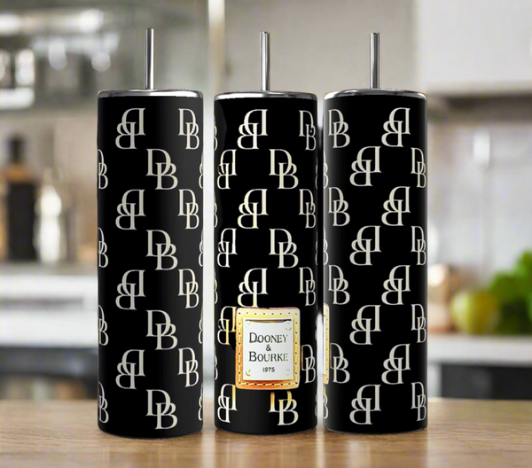 Three tall Kreative Kreationz Dooney and Bourke - Black 20oz Tumblers with white "DB" monograms and silver straws sit on a kitchen counter, featuring double-wall insulation for stylish, functional luxury beverage accessories.