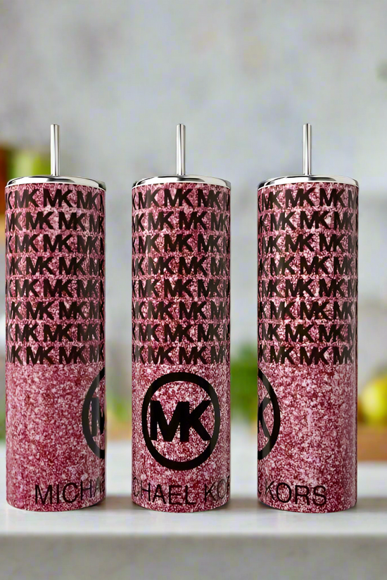 Three MK Pink Glittered 20oz Tumblers by Kreative Kreationz feature a sparkly pink finish with silver straws and luxe-inspired design, displayed on a white countertop against a softly blurred kitchen backdrop.