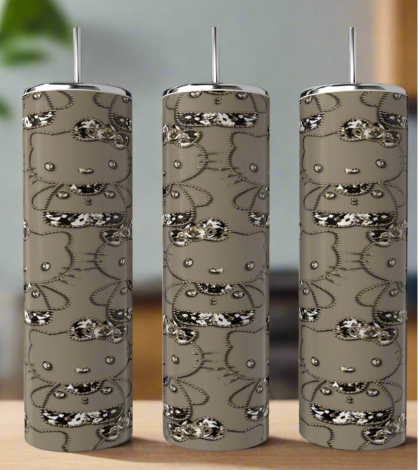 Three Kreative Kreationz Hello Kitty 20oz Tumblers with metallic lids and straws are displayed on a wooden surface, featuring eco-friendly stainless steel construction and black and white designs on a taupe background.