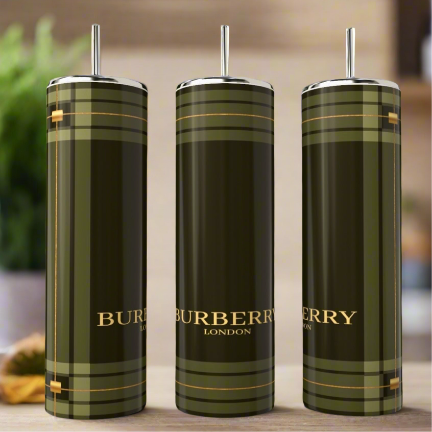 Three Burberry 20oz Skinny Tumblers by Kreative Kreationz are displayed with straws, showing a green and gold plaid pattern and logo. Add sophistication to your drinkware collection with these stylish stainless steel tumblers.