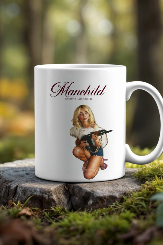 The Manchild Ceramic Mug 20oz Tumbler by Kreative Kreationz sits on a tree stump, showcasing a woman in a fur coat with a toy gun and 