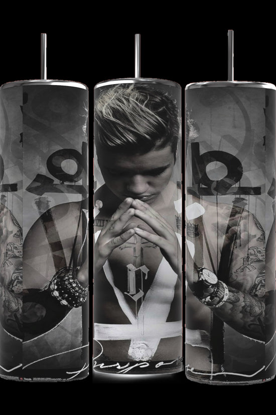 Three cylindrical Justin Bieber Prayer 20oz Tumblers by Kreative Kreationz feature monochrome images of a contemplative Justin Bieber, adorned with tattoos and wearing a sleeveless shirt and several bracelets. His hands are pressed together in a prayer-like gesture, with the word 