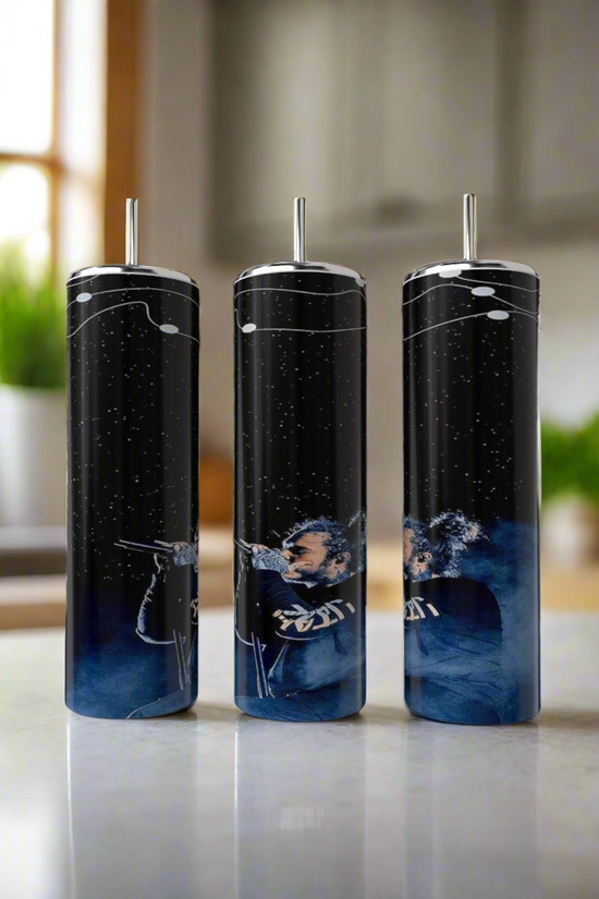 Three luxury-inspired Kreative Kreationz Post Malone Blue tumblers, crafted from high-quality stainless steel with a cosmic design in white and blue, stand on a kitchen counter beside a plant and window, creating a bright and modern setting.