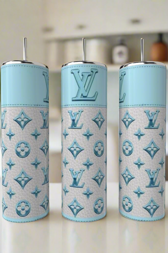 Three LV Sky Blue 20oz Tumblers by Kreative Kreationz, featuring a luxury-inspired light blue and white design with metal straws, are displayed on a white countertop in a modern kitchen.