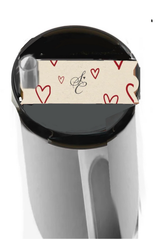 Viewed from above, the Sabrina Carpenter Heart Stanley Lid Topper by Kreative Kreationz features a silver finish with a paper band displaying red hearts and an elegant black 