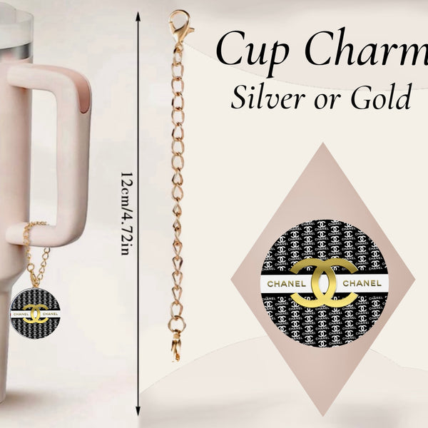 The Chanel Charm Dangle by Kreative Kreationz is a 12 cm handcrafted cup accessory in silver or gold. Featuring a black and white Chanel-inspired design, it hangs from a pale pink tumbler for a chic touch.