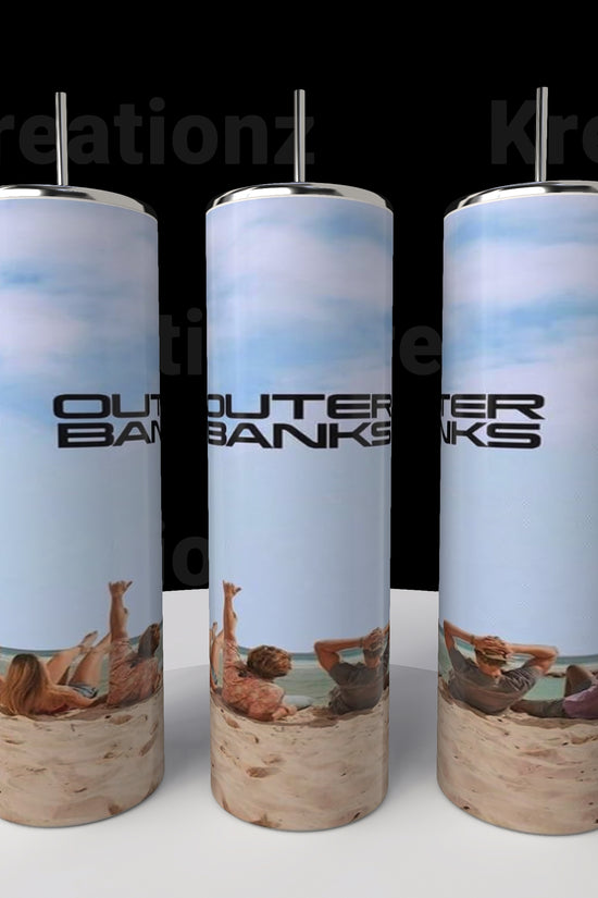 Three Outer Banks OBX 20oz Tumblers by Kreative Kreationz, featuring images of beach relaxation with blue skies and sands, are displayed on a circular platform. Each tumbler includes a spill-proof lid and straw.