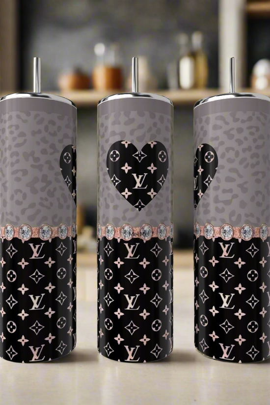 Three Kreative Kreationz LV Rose Gold Heart 20oz Tumblers, each with metal straws, are shown on a kitchen counter featuring gray and black leopard print, Louis Vuitton-inspired monograms, and a heart design on the center tumbler.