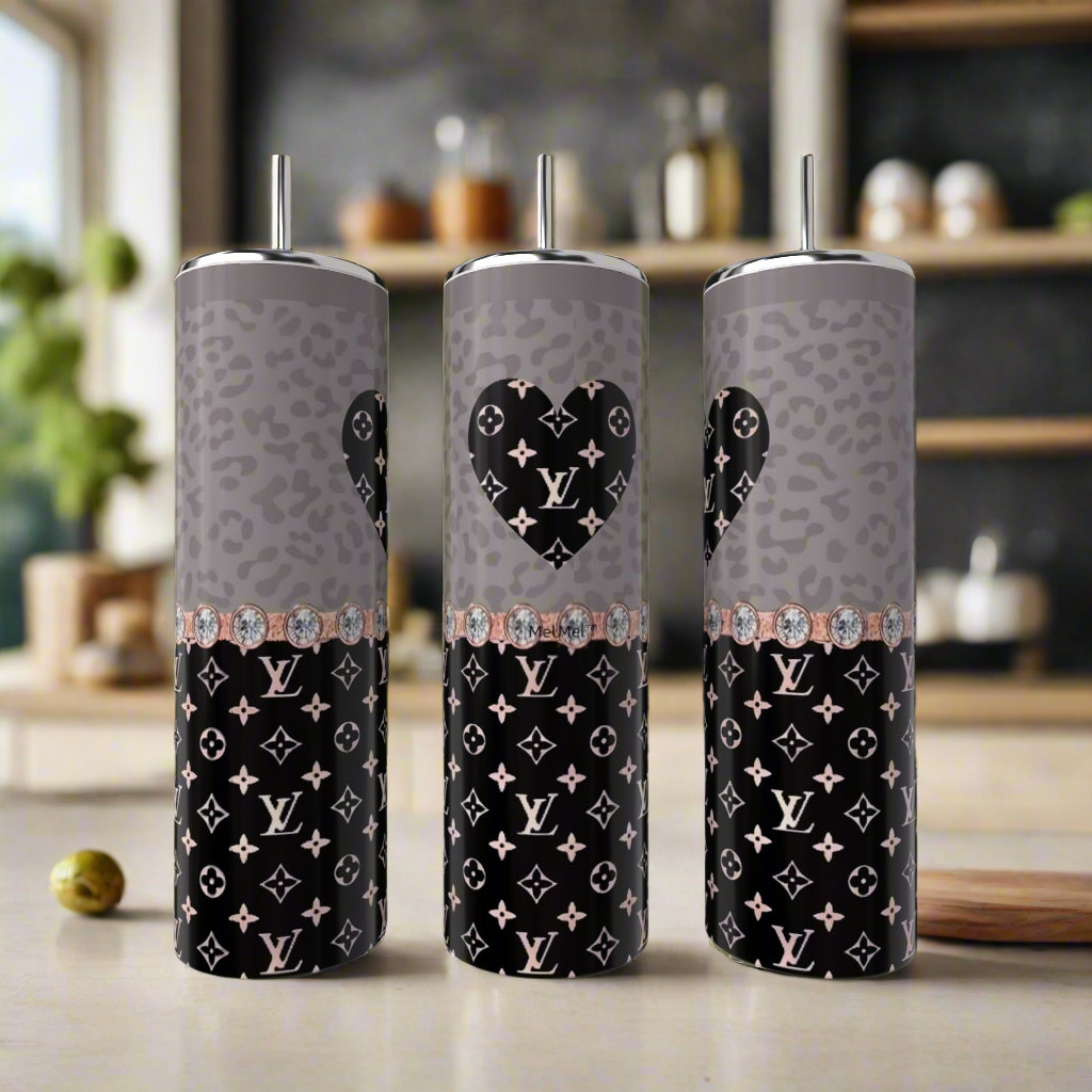 Three Kreative Kreationz LV Rose Gold Heart 20oz Tumblers, each with metal straws, are shown on a kitchen counter featuring gray and black leopard print, Louis Vuitton-inspired monograms, and a heart design on the center tumbler.