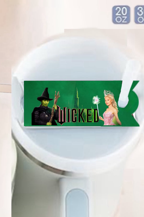 The Wicked -Stanley Lid Topper by Kreative Kreationz features a green Wicked-themed label with two characters on the Stanley tumbler’s white lid and size options (20 oz, 30 oz, 40 oz) in the upper right. A fun, durable tumbler accessory!.