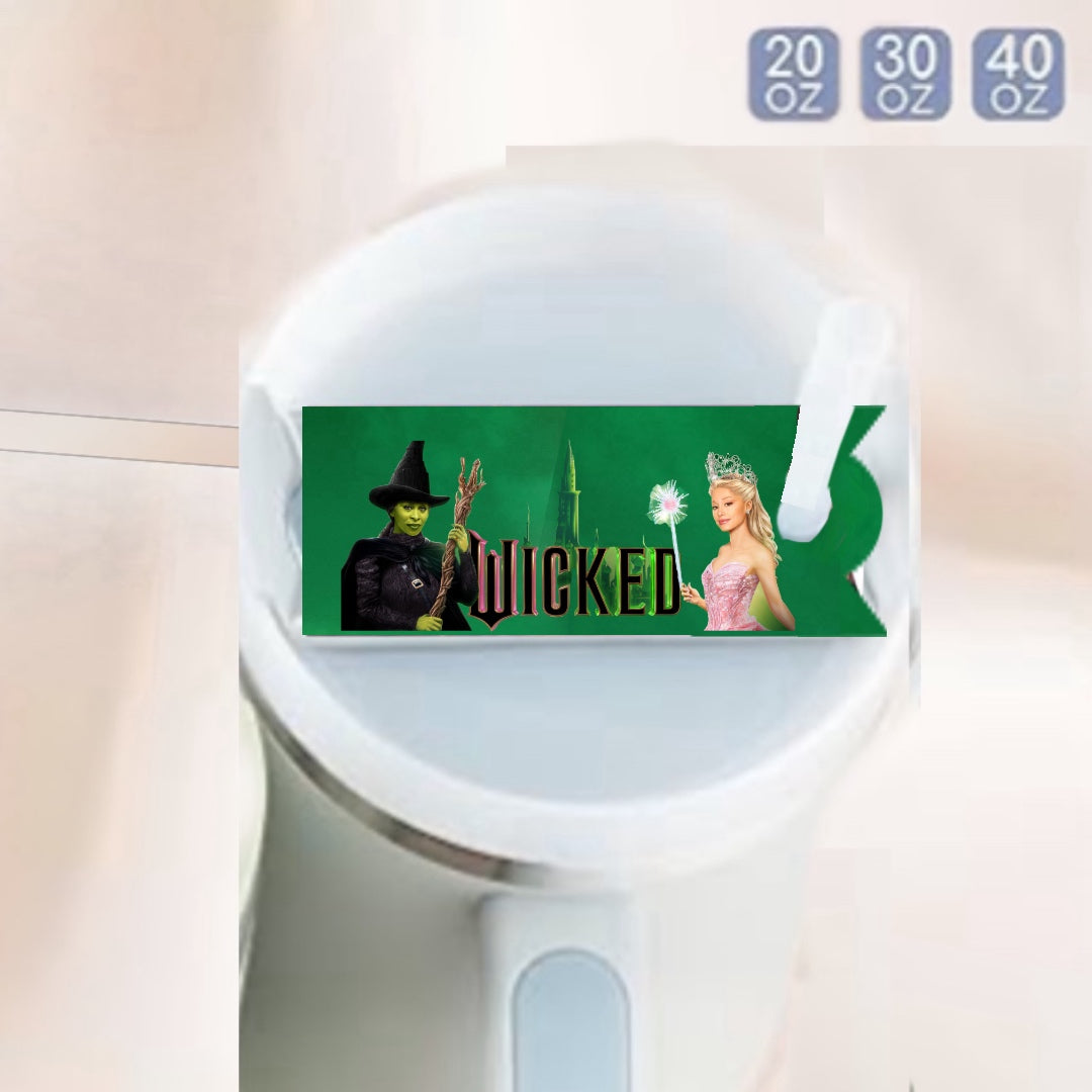 The Wicked -Stanley Lid Topper by Kreative Kreationz features a green Wicked-themed label with two characters on the Stanley tumbler’s white lid and size options (20 oz, 30 oz, 40 oz) in the upper right. A fun, durable tumbler accessory!.
