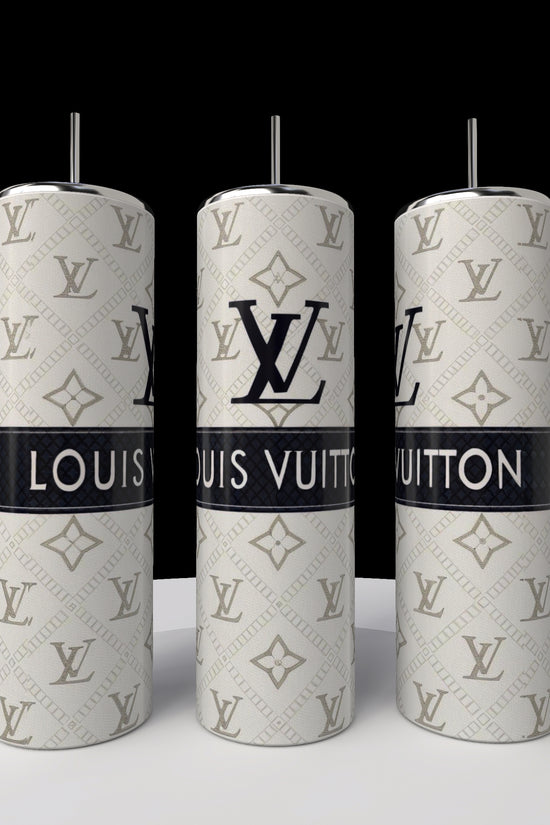 Three silver Kreative Kreationz LV 20oz Skinny Tumblers with straws are lined up on a white surface, showcasing black Louis Vuitton logos and branding on a patterned silver background. Their sleek, cylindrical design enhances the elegance against the black backdrop.