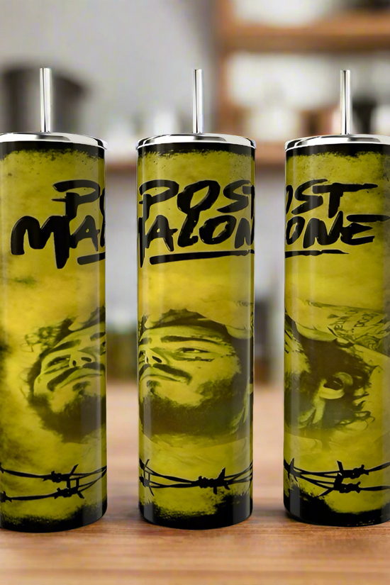 Three Post Malone 20oz tumblers by Kreative Kreationz, with lids and straws, sit on a wooden surface. Each stainless steel, eco-friendly tumbler showcases a yellow and black barbed wire design featuring text 