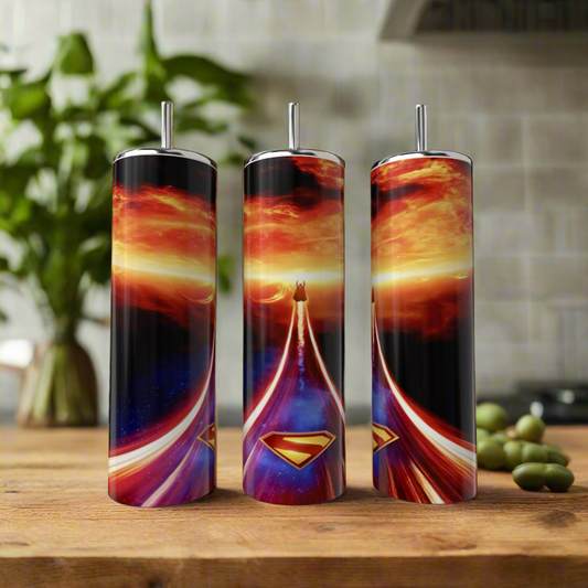 Three Kreative Kreationz Superman Fireball 20oz Tumblers with straws showcase vibrant designs and swirling skies, displayed on a wooden surface—ideal as reusable tumblers or in a stylish gift box tumbler set.