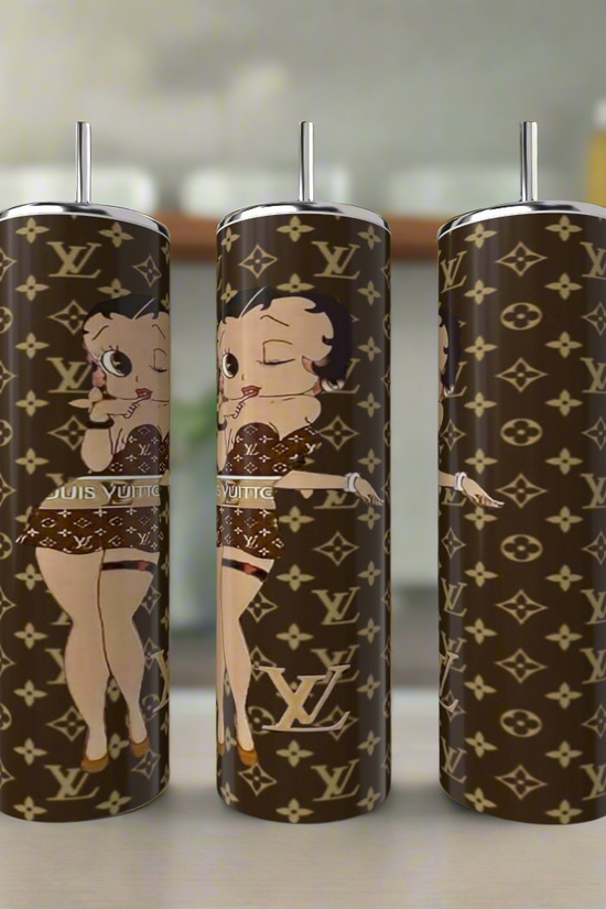 Three Betty B LV 20oz Skinny Tumblers from Kreative Kreationz, crafted in stainless steel with a luxury-inscribed design and an animated character, are showcased on a kitchen counter. The unique tumblers feature iconic logos paired with the beloved Betty Boop in a playful pose.