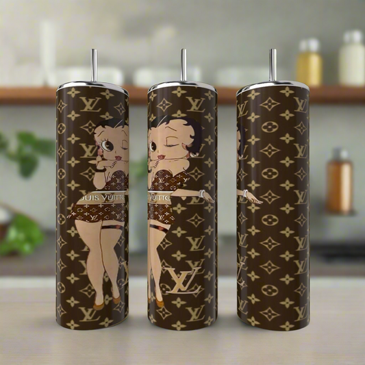 Three Betty B LV 20oz Skinny Tumblers from Kreative Kreationz, crafted in stainless steel with a luxury-inscribed design and an animated character, are showcased on a kitchen counter. The unique tumblers feature iconic logos paired with the beloved Betty Boop in a playful pose.