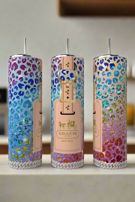 Three tall, skinny tumblers with colorful, glittery leopard print patterns and a 