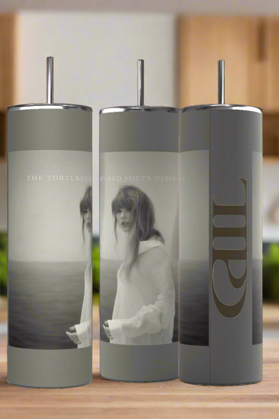Three Kreative Kreationz TTPD grey 20oz tumblers with straws are displayed on a modern kitchen counter, featuring grayscale ocean-themed images of a woman and 