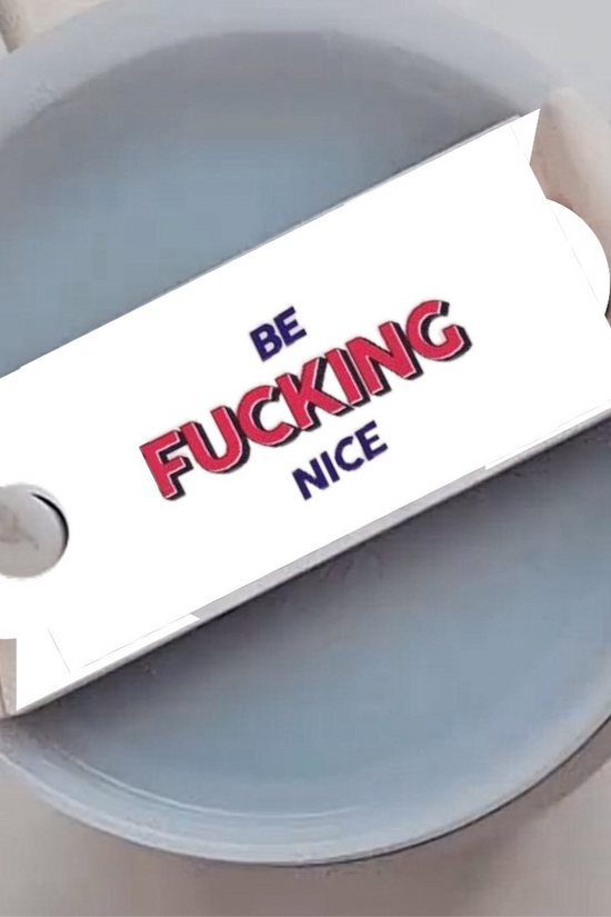 Close-up of a round, gray-colored object with a rectangular card attached to a stick in the middle. The card has the words 