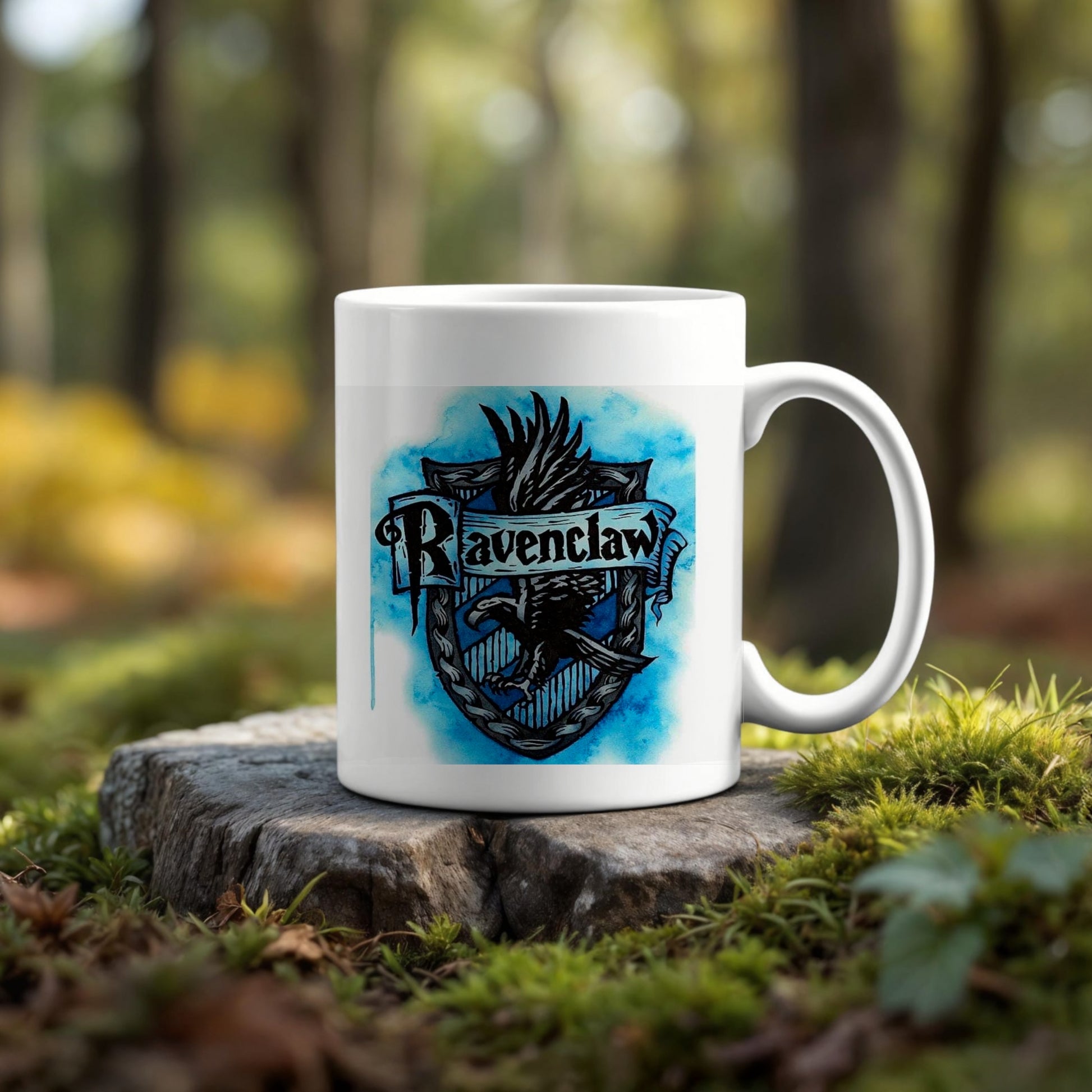 The Ravenclaw Ceramic Mug by Kreative Kreationz features a blue crest design and sits on a tree stump outdoors, blending with greenery and trees—an eco-friendly choice for any Harry Potter fan.