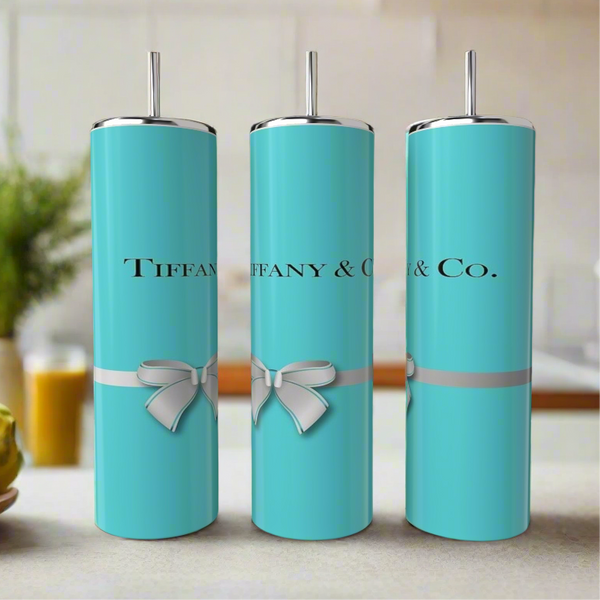 Three tall, turquoise Kreative Kreationz Tiffany 20oz Tumblers with silver lids and straws are displayed. Each stainless steel tumbler features a white bow design and the text "Tiffany & Co." in black.