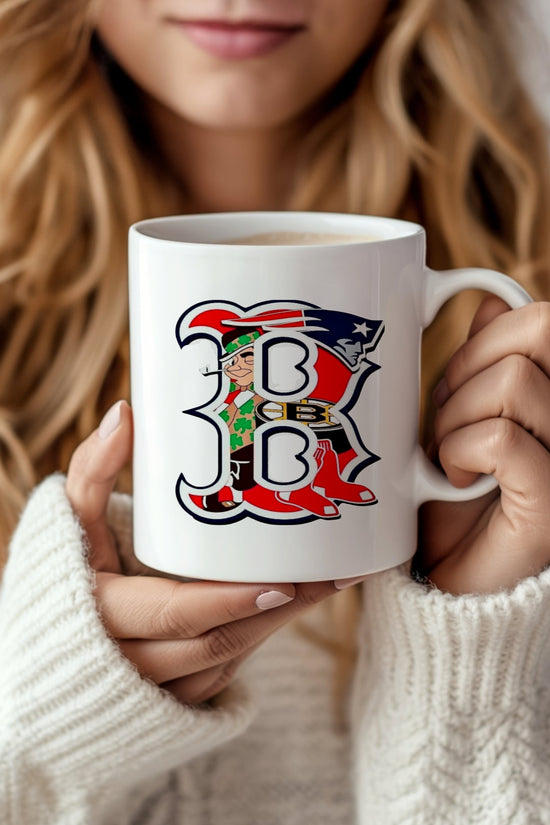 A woman with wavy blonde hair in a white sweater holds the Boston Ceramic Mug by Kreative Kreationz, featuring a large, ornate letter 