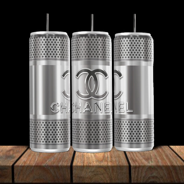 Three Kreative Kreationz Chanel Silver Stainless Steel 20oz tumblers with straws, textured design, and interlocking C’s logo are shown on wood against a black background—a true luxury drinkware statement.
