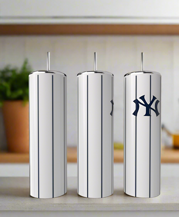 Three stainless steel tumblers with vertical pinstripes and metal straws by Kreative Kreationz are on a kitchen counter. The rightmost tumbler is the New York Yankees 20oz Tumbler with a dark blue Yankees-style logo.