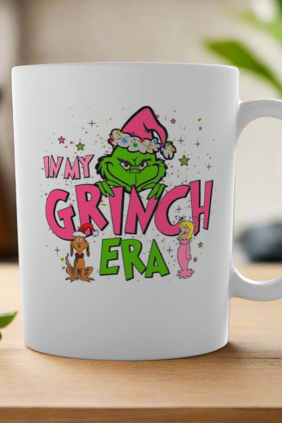 The Grinch Era Ceramic Mug from Kreative Kreationz features the Grinch in a Santa hat with “I’m in my Grinch era” and festive accents, perfect for fans of the classic Dr. Seuss story.