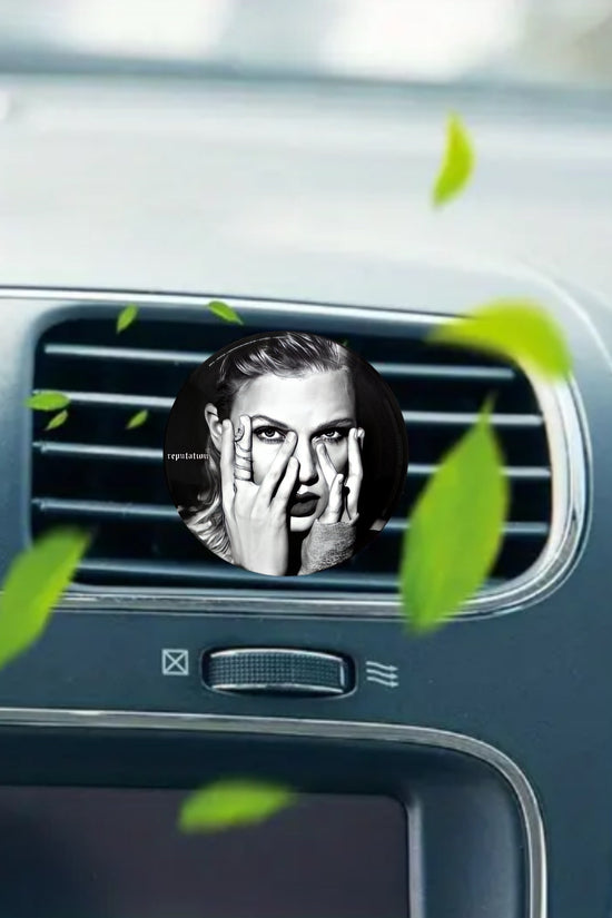 The REPUTATION Taylor Swift Car Air Freshener by Kreative Kreationz features a vinyl record design with a black-and-white portrait of Taylor Swift, partially covering her face with her hands and green leaves floating around.