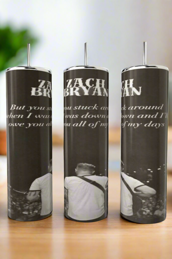 The Kreative Kreationz Zach Bryan Lyric 20oz Tumblers feature luxury-inspired stainless steel designs with black and white images, partial song lyrics, and “ZACH BRYAN” text. Photos show a man playing guitar on a wooden table.
