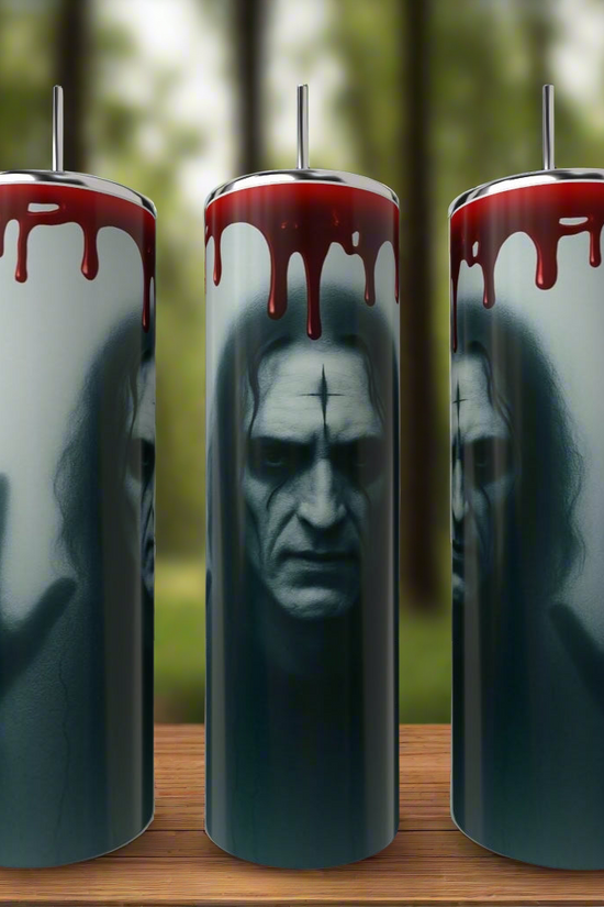 Kreative Kreationz’s The Crow 20oz Tumblers showcase a haunting pale man with hollow eyes and blood-like red liquid dripping, set against a blurred forest, on durable stainless steel drinkware.