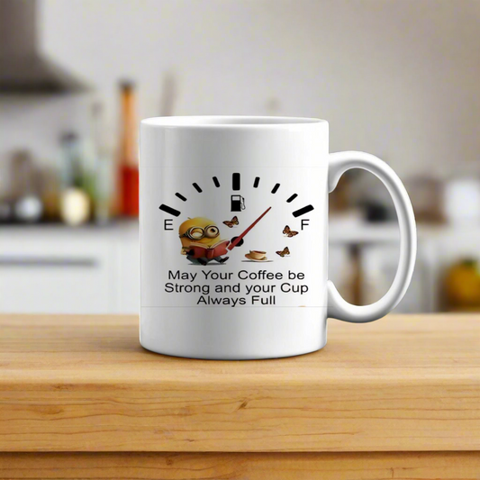 The Kreative Kreationz Minion Full Coffee Ceramic Mug shows a Minion with a coffee cup, a coffee gauge graphic, and the phrase “May Your Coffee be Strong and your Cup Always Full.” The custom mug is perfect for cozy kitchen vibes.