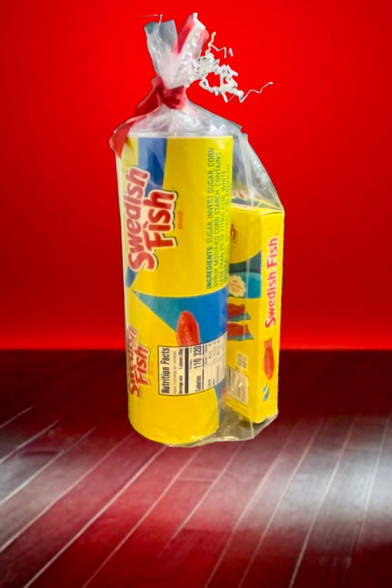 A plastic bag containing a Swedish Fish Gift Set with a 20oz stainless steel skinny tumbler, featuring yellow and blue packaging, branded 