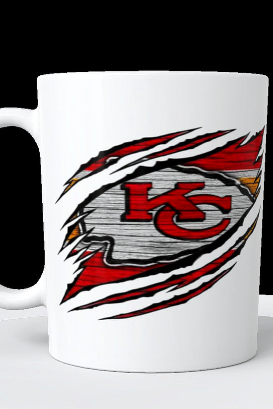The Chiefs Ceramic Mug | 11oz by Kreative Kreationz features the Kansas City Chiefs logo in red and yellow, appearing through claw marks on a wood-look background.