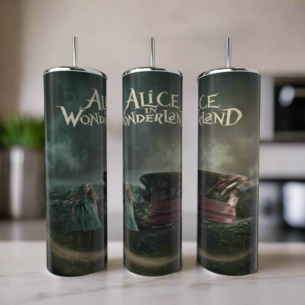 Three Kreative Kreationz Alice in Wonderland 20oz Tumblers with metal straws, featuring dark, whimsical designs and iconic characters, are displayed on a kitchen counter as stylish, eco-friendly drinkware.