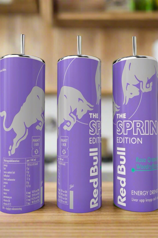 Three Spring purple Red Bull 20oz Tumblers by Kreative Kreationz with straws are displayed on a kitchen counter, featuring a luxury-inspired purple design and white bull logo, with 