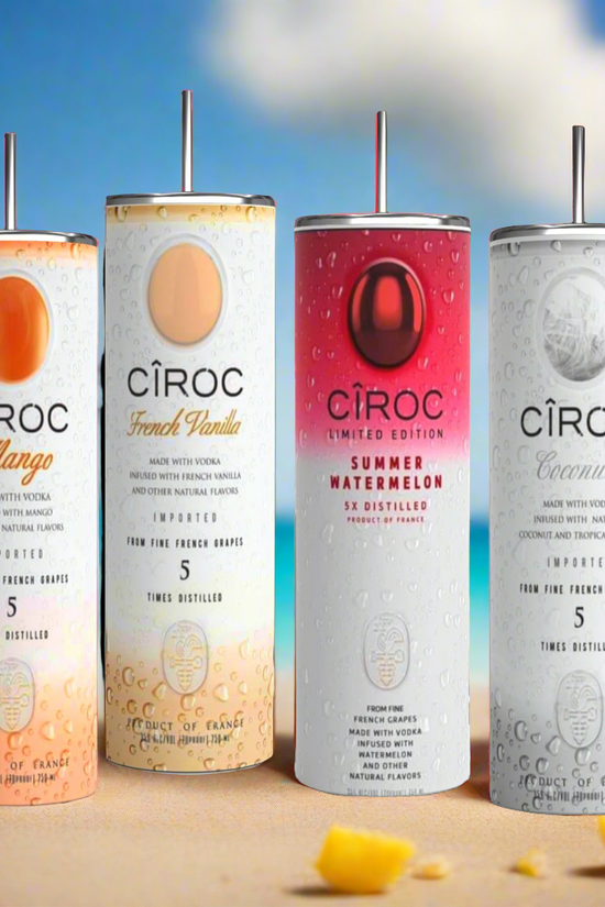 Two cans of Kreative Kreationz Ciroc 20oz Tumbler with 3D Lid Topper are shown on a wooden surface, reminiscent of travel tumblers. The left can is Red Berry flavor, topped with ice and a cherry. The right can is Vodka Snap Frost flavor, topped with ice and a lemon slice. Both cans feature product information and branding.
