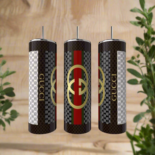 The Gucci 20oz Tumbler by Kreative Kreationz features luxury-inspired black-and-white patterns, metallic straws, and a gold logo with red and green stripes, all crafted from high-quality stainless steel for lasting style.