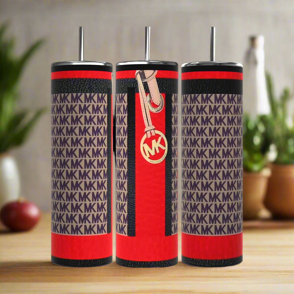 Three luxurious Kreative Kreationz MK Designer Inspired 20oz Tumblers display a chic red and black design with "MK" patterns. Made of stainless steel, each includes a metal straw, while one has a zipper and round "MK" logo tag, enhanced by green plants against a blurred kitchen backdrop.