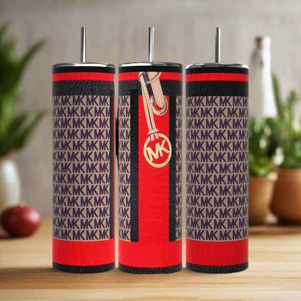 Three luxurious Kreative Kreationz MK Designer Inspired 20oz Tumblers display a chic red and black design with "MK" patterns. Made of stainless steel, each includes a metal straw, while one has a zipper and round "MK" logo tag, enhanced by green plants against a blurred kitchen backdrop.