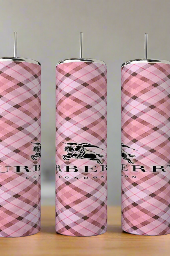 Three tall, cylindrical Burberry 20oz Skinny Tumblers by Kreative Kreationz stand upright with a pink plaid pattern and Burberry London logo, displayed on a blurred indoor background with greenery—ideal for any luxury tumbler collection.
