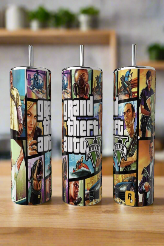 Three eco-friendly Kreative Kreationz Grabd Theft Auto 20oz Tumblers sit on a wooden surface, each featuring vibrant GTA artwork and logo, with a blurred kitchen backdrop highlighting their stylish design.