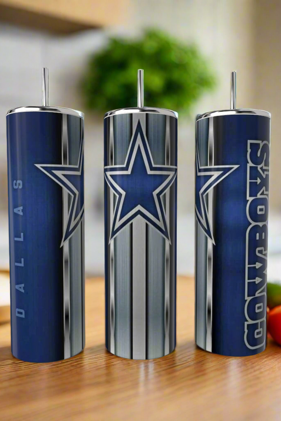 Three Kreative Kreationz Dallas Cowboys Stripe 20oz Tumblers with team logos and colors sit on a wooden kitchen counter, highlighting stylish, reusable drinkware. Tomatoes and other kitchen items are blurred in the background.