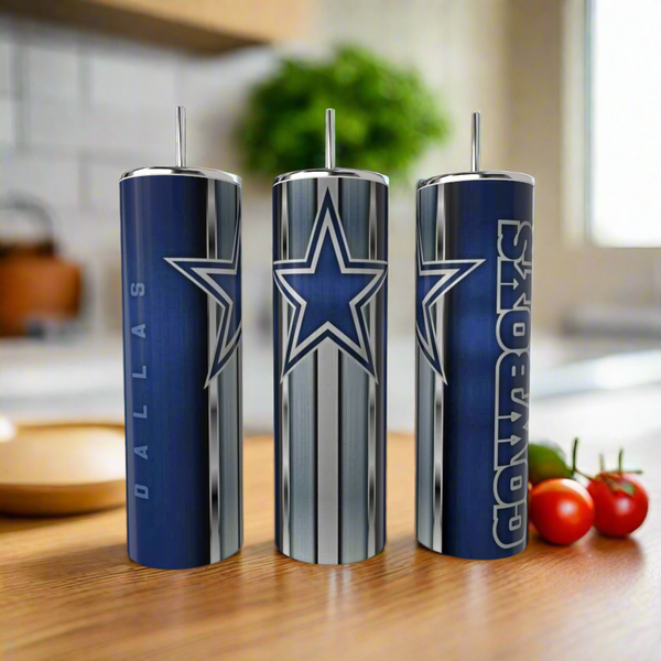 Three Kreative Kreationz Dallas Cowboys Stripe 20oz Tumblers with team logos and colors sit on a wooden kitchen counter, highlighting stylish, reusable drinkware. Tomatoes and other kitchen items are blurred in the background.