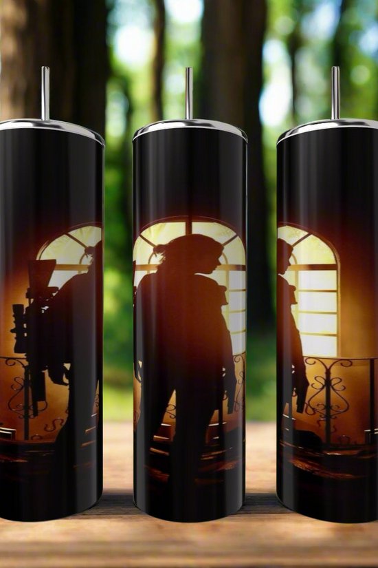 Set of three Kreative Kreationz This Is Us | Elle Game 20oz Skinny Tumblers with lids and straws, eco-friendly and reusable, feature silhouette art before backlit windows—perfect for fans. Shown outdoors on wood with a blurred forest background.