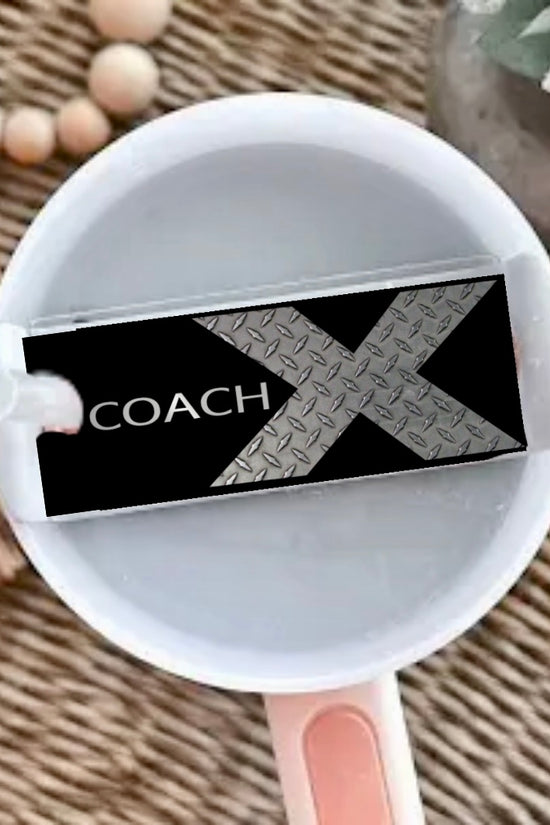 A Kreative Kreationz X Coach | Stanley Lid Plate/Topper decorates a white cup with liquid, featuring a 