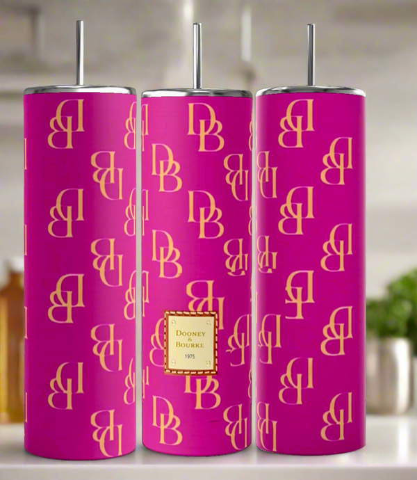 Three tall D&B Pink 20oz Tumblers by Kreative Kreationz feature yellow "DB" monograms, a "Dooney & Bourke 1975" label, and come with silver lids and straws, set against a blurred kitchen background.