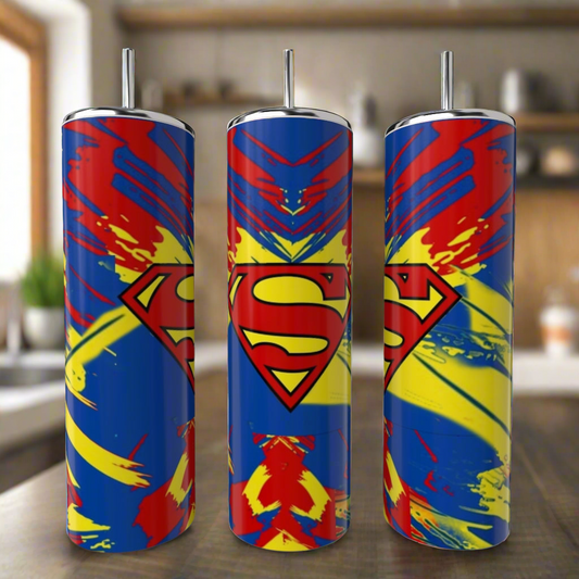 Three Superman Splash 20oz Tumblers by Kreative Kreationz, featuring bold red, blue, and yellow designs with the iconic “S” logo, stand on a kitchen counter—a vibrant eco-friendly drinkware set for fans.