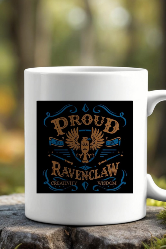 The Proud Ravenclaw Ceramic Mug by Kreative Kreationz rests on a mossy rock outdoors, displaying an eagle and the phrase 